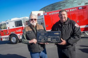 Morongo Tribal Chairman Robert Martin and Morongo Fire Chief Kevin Gaines hold a plaque before the new Morongo Fire Engine.